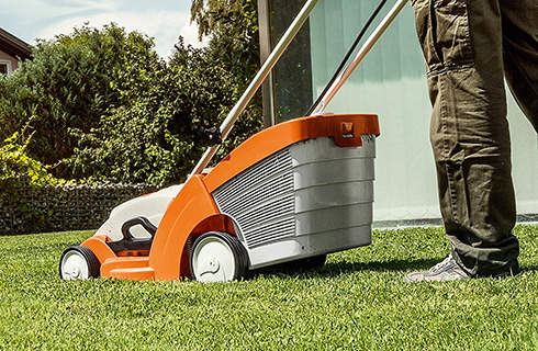 A STIHL RMA 339 cordless lawn mower being used on a green lawn