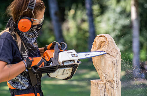 A wooden owl sculpture in progress: the wings are defined using a STIHL chainsaw with carving set.