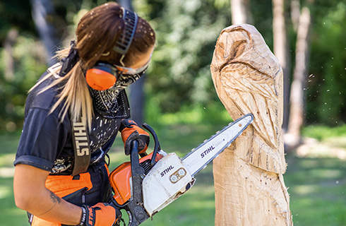 A wooden owl sculpture in progress: flight feathers are added using a STIHL chainsaw with carving set.