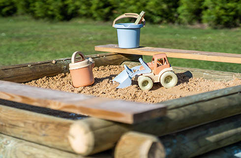 Toys for digging inside a DIY wooden sandpit.