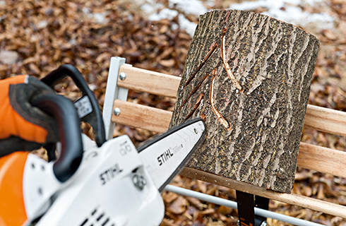 DIY log lantern: a pine tree pattern of light slits being cut with a STIHL MS 201 C-M petrol chainsaw with M-Tronic